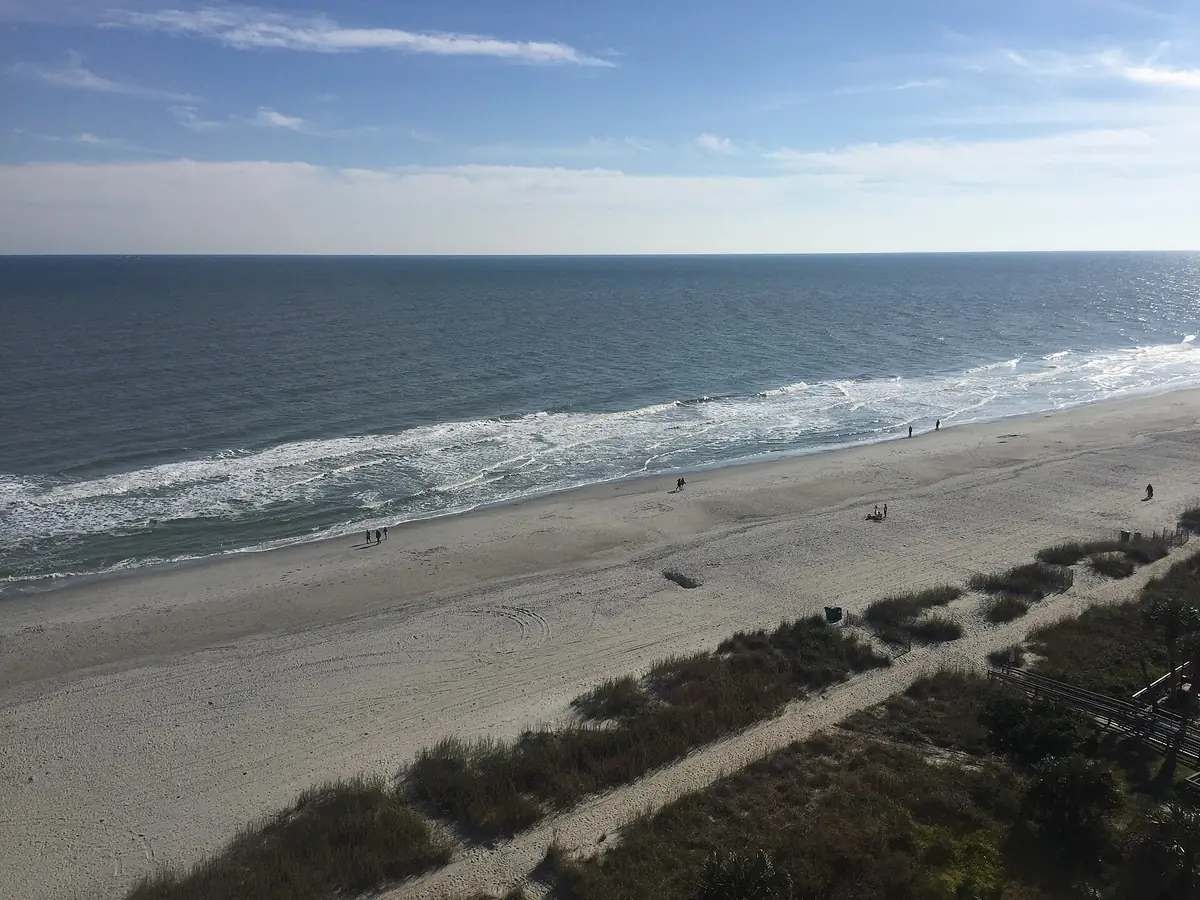 The wide sand beach, the dunes and the ocean in Myrtle Beach, seen from a high floor