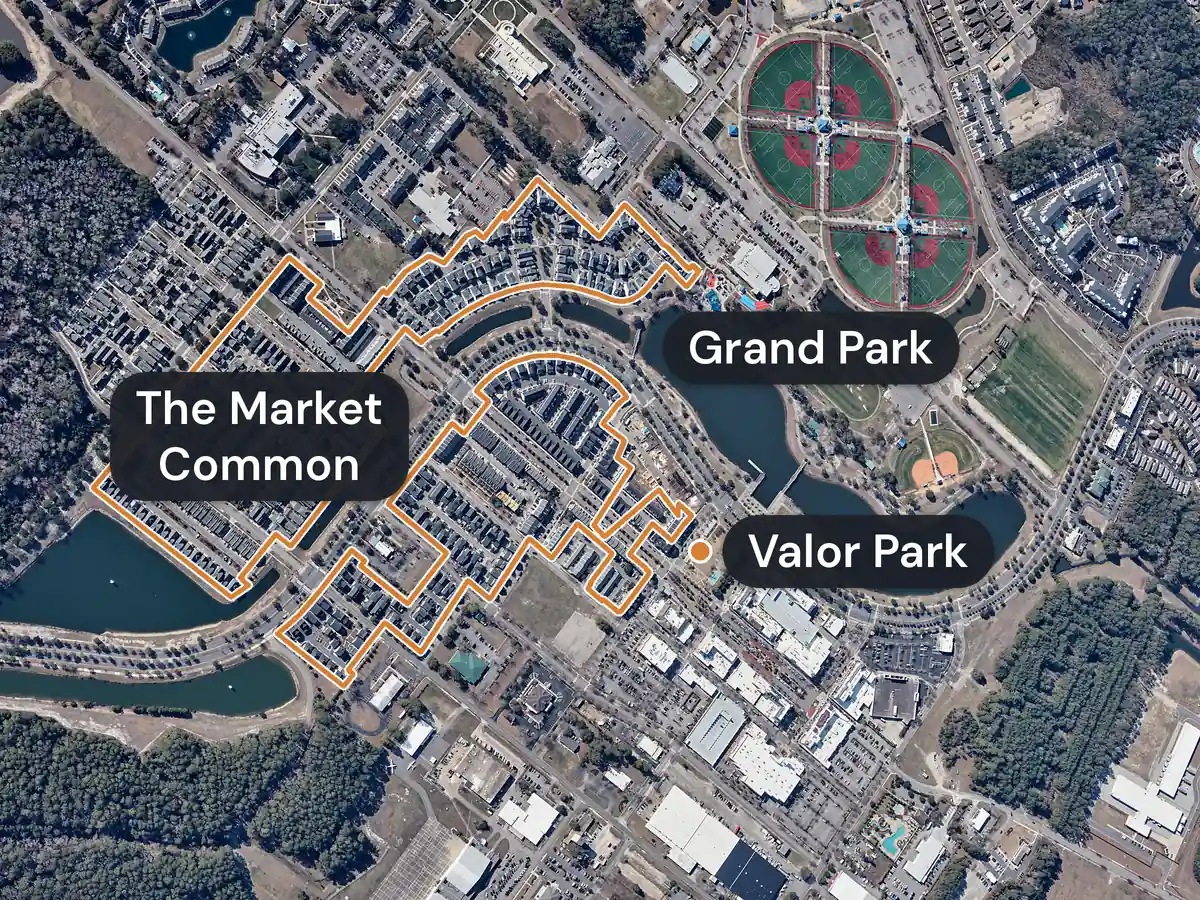The Market Common from the air: streets of homes outlined in orange beside a lake, a dot labelled Valor Park at the edge of the shops, and ball fields and a lake labelled Grand Park