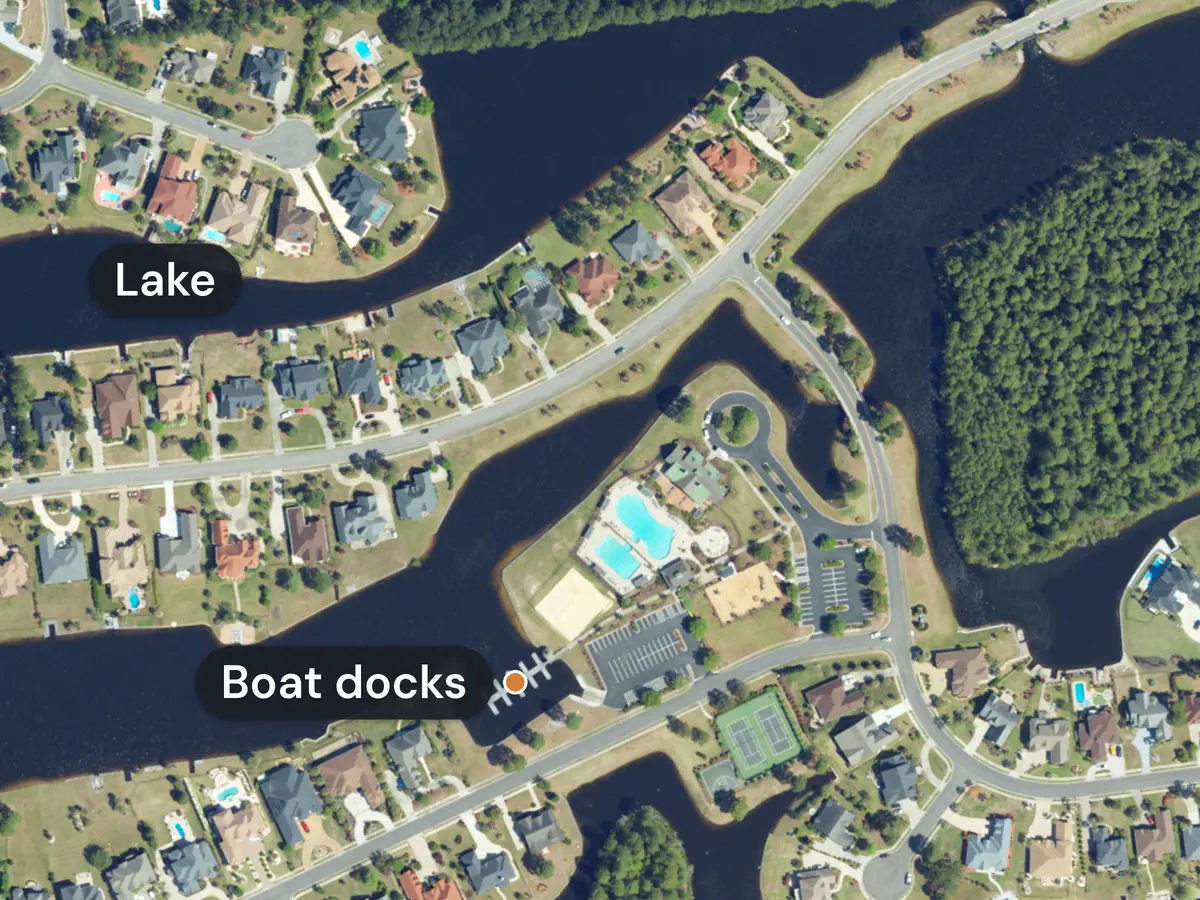 Plantation Lakes from above: houses with back yards on a dark winding lake labelled Lake, and a small boat dock, marked Boat docks, beside two pools